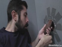 Bearded white man sucking and fucking a black cock at a gloryhole