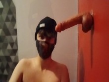 Femboy esposada chupa un consolador con una jaula de castidad