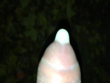 Primer plano llenando condón con semen en público