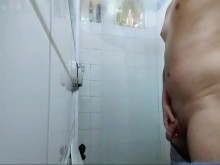 chico guapo cepillándose los dientes en la ducha.