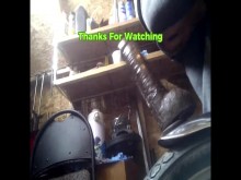 PV montando un gran juguete negro hasta las pelotas en el guardabarros de la bicicleta en un cobertizo